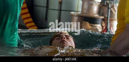 161110-N-OI810-408 PHILIPPINENSEE (10. November 2016) Petty Officer 3rd Class Collin Cogan, von Jackson, Michigan, ist während einer Taufe im Hangar Bucht von der Marine nur vorwärts bereitgestellt Flugzeugträger USS Ronald Reagan (CVN-76) getauft. Elf Matrosen wurden während der Zeremonie unter der Leitung von des Schiffs Befehl religiösen Ministerien Abteilung getauft. Ronald Reagan, das Flaggschiff der Carrier Strike Group fünf (CSG 5), ist auf Patrouille in der Philippinensee, Sicherheit und Stabilität in der Indo-Asien-Pazifik-Region zu unterstützen. (Foto: U.S. Navy Petty Officer 3rd Class Nathan Burke/freigegeben) Stockfoto