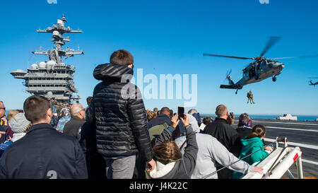 161229-N-BL637-124 Pazifik (29. Dezember 2016) Freunde und Familie von Matrosen auf dem Flugzeugträger USS Carl Vinson (CVN-70) zugewiesen beobachten eine Air Power Demonstration auf dem Flugdeck. Carl Vinson ist Gastgeber für mehr als 2.000 Familienmitgliedern und Freunden, um das Schiff Fähigkeiten zu demonstrieren. (Foto: U.S. Navy Mass Communication Specialist 2. Klasse Sean M. Castellano/freigegeben) Stockfoto