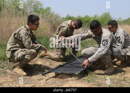 Soldaten, 70. Brigade Support Battalion, 210. Feldartillerie Brigade zugewiesen 2nd Infantry Division/ROK / USA kombiniert Division passt die Träger eines Wurfes vor der Verladung in den Bereich Wurf Krankenwagen im Rahmen einer MEDEVAC-Ausbildung bei LTA130, Südkorea, 3. Mai 2017. Training über die ordnungsgemäße Beladung und Entladung Verfahren eine FLA beinhaltet Nummerierung Wurf Träger und formale Befehle sorgt dafür, dass jeder Soldat seine/ihre Rolle als auch die Arbeit im Team lernt. Stockfoto