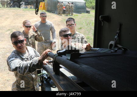 Soldaten, 70. Brigade Support Battalion, 210. Feldartillerie Brigade zugewiesen 2nd Infantry Division/ROK / USA kombiniert Division lädt einen Wurf in ein M997, ein Feld Wurf Krankenwagen, bei LTA130, Südkorea, 3. Mai 2017. Die MEDEVAC-Ausbildung bietet Soldaten Möglichkeiten, ihre Fähigkeiten zu verbessern und ihre Krieger Aufgaben beherrschen. Stockfoto