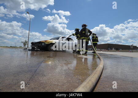 Mitglieder der Tinker Feuer und Notdienste, 72. Bauingenieur-Geschwader, arbeiten zusammen, um ein Fahrzeug Feuer 4. Mai 2017, Tinker Air Force Base in Oklahoma zu löschen. William Green Schläuche innerhalb des Wagens nach unten, während Captain David Jones mit dem Schlauch als Aaron Simpson, hilft ganz rechts steht-durch mit einem Feuer-Axt. Das privat geführte Fahrzeug entwickelt mechanische Probleme und fing Feuer in der Nähe von Oklahoma City Air Logistics Complexs Gebäude 9001. (U.S. Air Force Photo/Greg L. Davis) Stockfoto