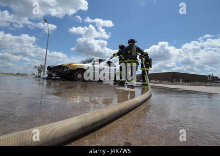 Mitglieder der Tinker Feuer und Notdienste, 72. Bauingenieur-Geschwader, arbeiten zusammen, um ein Fahrzeug Feuer 4. Mai 2017, Tinker Air Force Base in Oklahoma zu löschen. William Green Schläuche innerhalb des Wagens nach unten, während Captain David Jones mit dem Schlauch als Aaron Simpson, hilft ganz rechts steht-durch mit einem Feuer-Axt. Das privat geführte Fahrzeug entwickelt mechanische Probleme und fing Feuer in der Nähe von Oklahoma City Air Logistics Complexs Gebäude 9001. (U.S. Air Force Photo/Greg L. Davis) Stockfoto