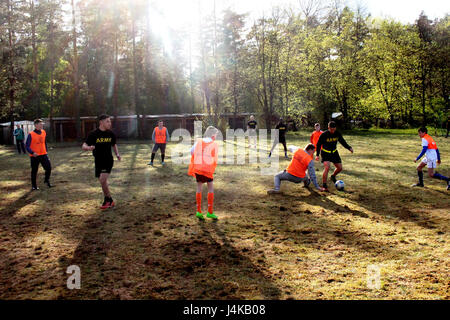 Kampfgruppe Soldaten spielen Fußball mit Schüler der vierten Klasse der Gen Jozefa Bema, während ein Fußball-Tag im Bemowo Piskie Mai 8. Die Soldaten wurden zu der örtlichen Mittelschule eingeladen, um ein paar Spiele der Fußball mit den Schülern der Schule als Zeichen des guten Willens und Freundschaft zu genießen. (US Armee-Foto von Pfc. Brandon Shiplett/freigegeben) Stockfoto