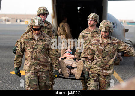SPC. Jesse Teniente, Spc. Gabriela Castillo, Spc. Zac Elenghan und Pfc. Eric Brennick, bekämpfen Mediziner mit dem 86. Combat Support Hospital bewegen einen simulierten Unfall aus einem MV-22 Osprey, während einer gemeinsamen Übung mit Marines aus Marine Medium Tiltrotor Squadron - 364 (VMM-364), am Camp Arifjan, Kuwait, 8. Mai 2017. (US Armee-Foto von Sgt. Christopher Bigelow) Stockfoto