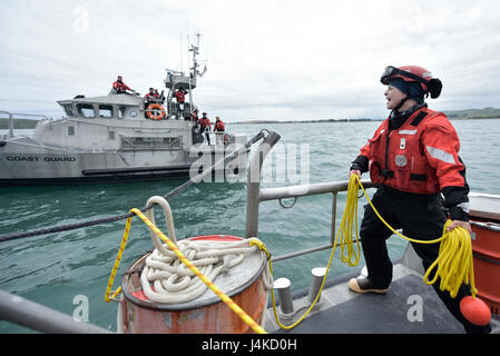 Seaman Julia Harris, eine Boot-Crew-Mitglied bei der Coast Guard Station Bodega Bay, Kalifornien, klingt ab vor dem Wurf einer Wurfleine an einer Partner-Crew während der Ausbildung an Bord ein 47-Fuß-Motor-Rettungsboot, 6. April 2017 Bootscrew. Klingende off ist ein wichtiger Bestandteil der Kommunikation bei risikoreichen SAR Missionen. (Foto: U.S. Coast Guard Petty Officer 3rd Class Sarah Wilson) Stockfoto