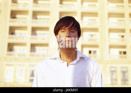 Mann, sehen junge, ernst, Kamera, Portrait, Porträt der eines Mannes, dunkelhaarige, Frisur, außerhalb der Saison, Sommer, Abendlicht, Hintergrund, Hotelanlage, Appartementhaus, Balkone Stockfoto