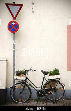 Ein altes Fahrrad dekoriert mit Blumenkästen am Gepäckträger. Stockfoto