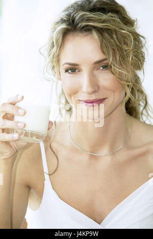 Frau, Lächeln, jung, fröhlich, Brusthaut Glas trinken, Porträt Frauen Porträt, 20-30 Jahre, blond, Langhaarig, Schlösser, Natur, Natürlichkeit, genießen, Glas, Milch, Kuhmilch, trinken, gesunde Ernährung, ernährungsbewusste, im Bewusstsein der Gesundheit, Kalzium-haltige, Kalzium, innen Stockfoto