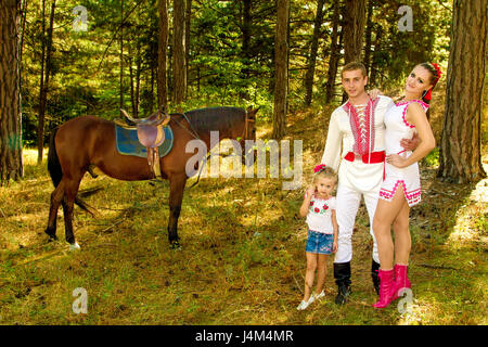 ein Ukrainer Mama und Papa und Tochter im Wald mit einem Pferd Stockfoto