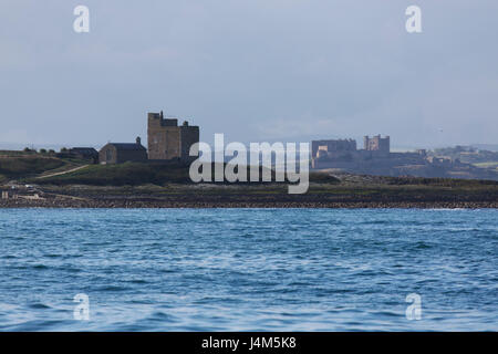 Kapelle St. Cuthbert und Castell Turm auf Inner Farne Island und Bamburgh Castle, auf der Küste von Northumberland in England. Stockfoto