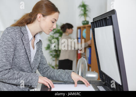 lächelnde Geschäftsfrau mit Kopierer Maschine Stockfoto