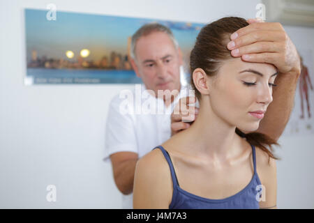 Physiotherapeuten, die Patienten Hals massieren zu beruhigen Stockfoto