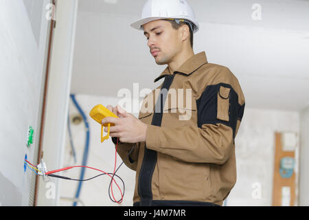 junger Ingenieur mit einem digitalen multimeter Stockfoto