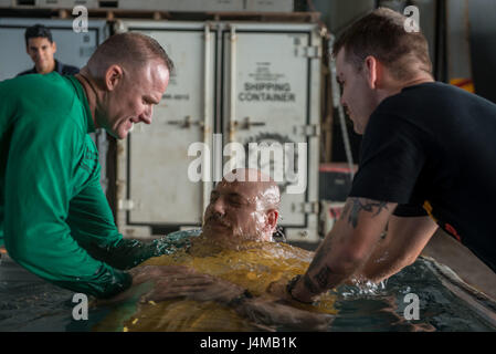 161110-N-OI810-378 PHILIPPINENSEE (10. November 2016) Petty Officer 1st Class (AW) David Cerankowski von Pueblo, Colorado, ist während einer Taufe im Hangar Bucht von der Marine nur vorwärts bereitgestellt Flugzeugträger USS Ronald Reagan (CVN-76) getauft. Elf Matrosen wurden während der Zeremonie unter der Leitung von des Schiffs Befehl religiösen Ministerien Abteilung getauft. Ronald Reagan, das Flaggschiff der Carrier Strike Group fünf (CSG 5), ist auf Patrouille in der Philippinensee, Sicherheit und Stabilität in der Indo-Asien-Pazifik-Region zu unterstützen. (Foto: U.S. Navy Petty Officer 3rd Class Nathan Burke/freigegeben Stockfoto