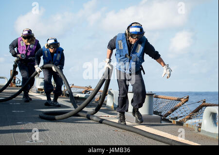 161110-N-UF697-105 PHILIPPINENSEE (10. November 2016) Petty Officer 3rd Class Remigio Vallin, rechts, Seaman Zymon A. Aguila, Center und Petty Officer 2. Klasse Christain C. Murphy, links, tragen eine Kraftstoff Schlauch nach Betankung eine MH-60R Sea Hawk Hubschrauber, von der "Saberhawks" der Hubschrauber Maritime Streik Squadron (HSM) 77, auf dem Flugdeck der vorwärts bereitgestellt Arleigh Burke-Klasse geführte Flugkörper Zerstörer USS Barry (DDG-52) bei scharfen Schwert 17 (KS17). KS17 ist eine Biennale, Vorsitzender von der unter der Regie der Joint Chiefs Of Staff, US Pacific Command-geförderten Bereich Training Übung (FTX). KS17 ist design Stockfoto