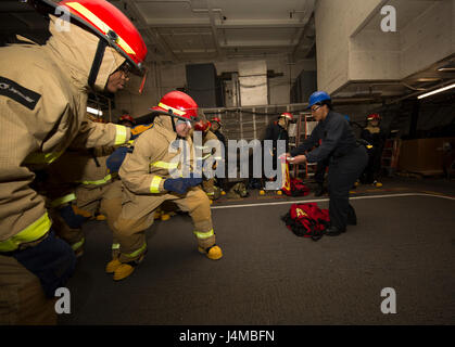 170208-N-IK431-042 NEWPORT NEWS, Virginia (8. Februar 2017) Maschinist ist Mate 2. Klasse Class Sharok Stephenson, Fairfax, Virginia, erläutert die Feuerwehrschläuche zu behandeln und simuliert eine Klasse alpha Feuer während einer allgemeinen Viertel Drill an Bord Flugzeugträger der Nimitz-Klasse USS Abraham Lincoln (CVN-72). Allgemeine Viertel Bohrer wird verwendet, um tatsächliche Opfer zu simulieren und trainieren Segler wie Sie richtig reagieren auftreten sollte. (Foto: U.S. Navy Mass Communication Specialist 3. Klasse Aaron T. Kiser/freigegeben) Stockfoto