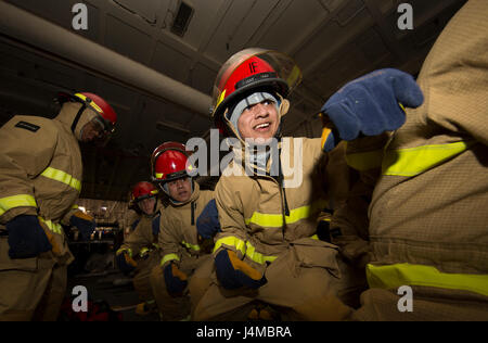 170208-N-IK431-033 NEWPORT NEWS, Virginia (8. Februar 2017) Luftfahrt Elektroniker / 3. Klasse Cesar Cuevas, aus Los Angeles, beteiligt sich an Feuerwehrschlauch Umgang mit Training während einer allgemeinen Viertel Drill an Bord Flugzeugträger der Nimitz-Klasse USS Abraham Lincoln (CVN-72). Allgemeine Viertel Bohrer wird verwendet, um tatsächliche Opfer zu simulieren und trainieren Segler wie Sie richtig reagieren auftreten sollte. (Foto: U.S. Navy Mass Communication Specialist 3. Klasse Aaron T. Kiser/freigegeben) Stockfoto