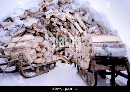 Schneebedeckte Brennholz auf Holzschlitten Stockfoto