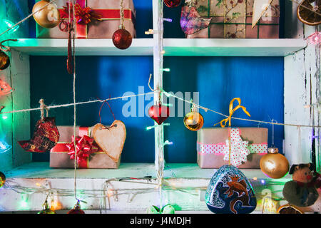 Geschenk-Boxen auf Holzregalen in der Nähe von Ornamenten Stockfoto