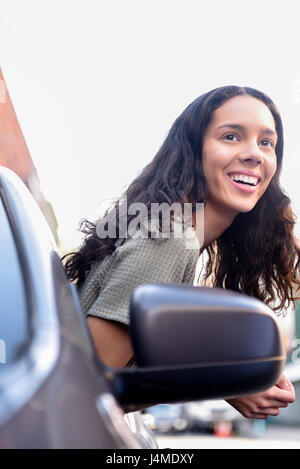 Hispanic Frau aus Autofenster gelehnt Stockfoto