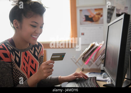 Gemischte Rennen Frau online-shopping mit computer Stockfoto