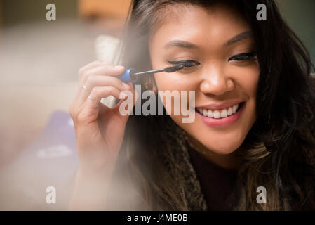 Gemischte Rennen Frau Wimperntusche auftragen Stockfoto