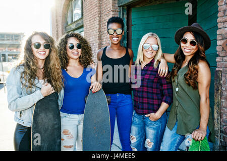 Frauen posieren mit Skateboards in Stadt Stockfoto