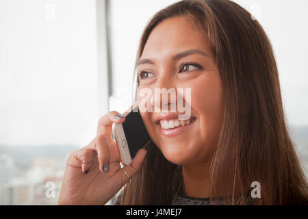 Lächelnde Hispanic Frau am Handy Stockfoto