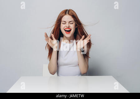 Aufgeregt kaukasischen Frau an windigen Tisch Stockfoto