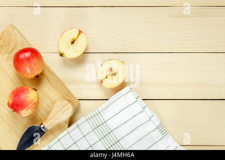 Draufsicht roten Apfel in Scheiben, Messer, Serviette auf Holz. Stockfoto