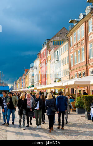 Dunkle Wolken über der geschäftigen und bunten Quayside entfernt von Nyhavn in Kopenhagen. Dänemark. beliebten touristischen Zentrum mit Bars und Restaurants. Stockfoto