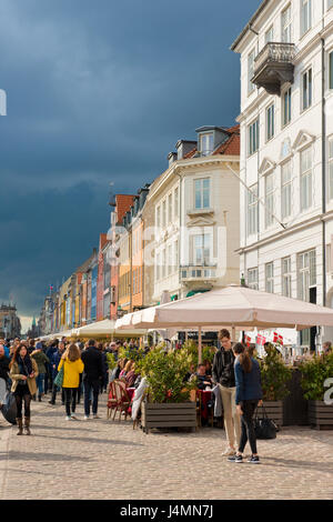 Dunkle Wolken über der geschäftigen und bunten Quayside entfernt von Nyhavn in Kopenhagen. Dänemark. beliebten touristischen Zentrum mit Bars und Restaurants. Stockfoto