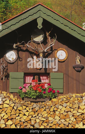 Deutschland, Oberbayern, Jagd, Lodge, Detail, Fenster, Brennholz Bayern, Werdenfels, Geigenbau Ort, Holzhaus, Stahlwerke, Fassade, Hirschgeweih, Schutz-Scheiben, Figur eines Heiligen, Blumenschmuck, Geranien, Holzarbeiten, gestapelt, gestapelt, Lager, Konzeption, ländlich, Idylle, Holz-Heizung, Holz Brennofen, Gemütlichkeit Stockfoto