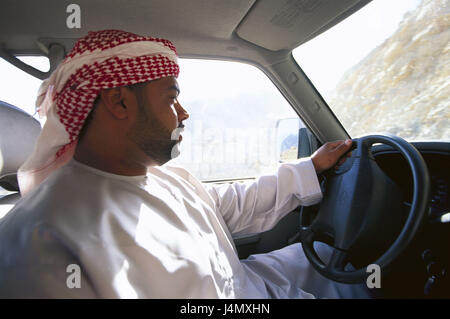 Oman, Halbinsel Musandam, Fahrer, in der Nähe Khasab, Lauffläche, kein Model-Release! Front-Osten, im Nahen Osten, Naher Osten, Arabische Halbinsel, Sultanat Oman, Musandam Region, lokale, traditionell, Kleidung, Kopfbedeckungen, Turban, Auto, fahren, Verkehr, Transport, Autofahren, an der Seite Stockfoto