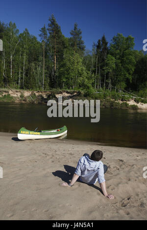 Lettland, Sigulda, Gauja Fluss, Ufer, Kanu, Mann, Entspannung, Rückansicht, Stockfoto