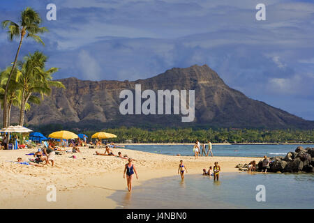 USA, Hawaii, Oahu Island, Honolulu, Waikiki Beach, Badegäste, die Hawaii-Inseln, Destination, Strand, Sandstrand, Strand, Urlaub, Urlaub, Urlauber, Person, Tourist, Tourismus, sonnen sich, haben ein Bad, Meer, Palmen, Berge, Stockfoto