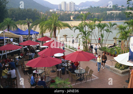 China, Hong Kong, Lantau Island, Discovery Bay, Water Margin Restaurant, Meer, Asien, Insel, Küste, Küstenlandschaft, Stadt, Blick auf die Stadt, Strand, Sandstrand, Gastronomie, Water Margin-Restaurant, Restaurant-Komplex, Restaurant, Restaurant-Terrasse, Strandbar, Strandcafé, Person, Gäste, Palmen, Tourismus, Stockfoto