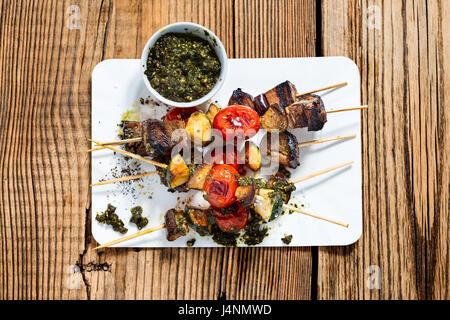 Gegrilltem Gemüse und Rindfleisch Shish Kabobs am Spieß mit Pesto auf rustikalen Holztisch von oben gesehen Stockfoto