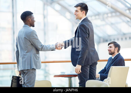 Porträt des Lächelns erfolgreicher Geschäftsmann Gruß afrikanisch-amerikanischer Mann treffen Händeschütteln am Tisch im Bürogebäude Stockfoto