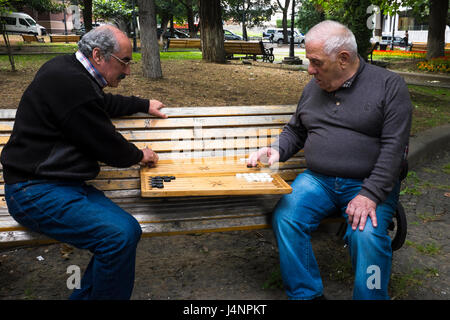 Zwei ältere Männer spielen Backgammon oder shesh Besh, auf einer Parkbank im Zentrum von Tiflis. Republik Georgien Stockfoto