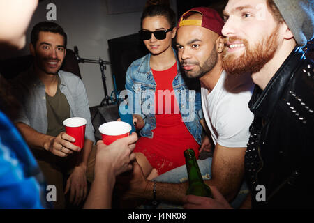 Multi-ethnischen Gruppe von jungen Leuten hängen in Nachtclub spät in die Nacht feiern und trinken Bier Stockfoto