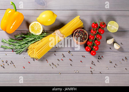 Spaghetti, Cherry Tomaten, Olivenöl und Gewürzen auf alten grauen Hintergrund Holz Stockfoto