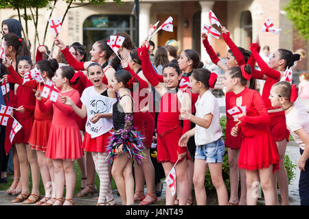 Eine Menge von Kindern und Jugendlichen in Nationaltracht Welle Fahnen, georgischen Unabhängigkeitstag in Mzcheta in Georgien zu feiern. Stockfoto