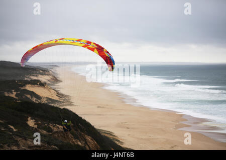 Eine weibliche Gleitschirmpilot soaring Aberta Nova Beach. Stockfoto