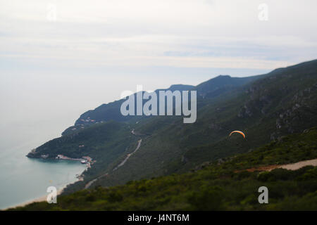 Eine miniaturisierte Ansicht (mit einem Tilt-Shift-Objektiv) von einem Gleitschirm fliegen in Serra da Arrábida, Portugal Stockfoto