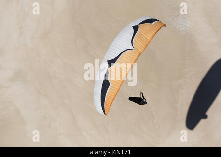 Ein Paragliding Pilot über den Sand an Aberta Nova Strand fliegen. Stockfoto