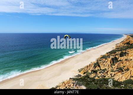 Ein Gleitschirm über Aberta Nova Strand fliegen. Stockfoto