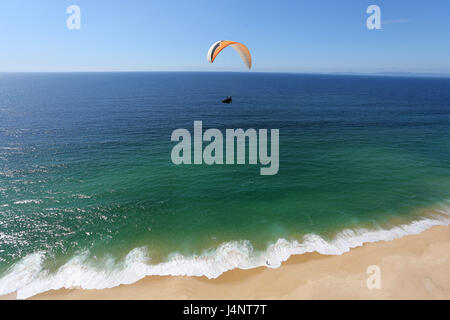 Ein Gleitschirm über Aberta Nova Strand fliegen. Stockfoto