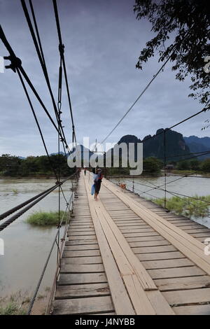 Vang Vieng, Laos-Oktober 13, 2015: Einheimische Frauen die Brücke Maut Abschnitt 1 über den Nam Song River mit ihre Besetzung-Netze in der hand wie sie Angeln gehen Stockfoto