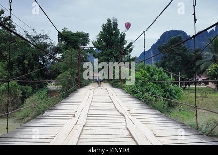 Vang Vieng, Laos-Oktober 13, 2015: Mann auf dem Motorrad durchquert der Mautbrücke Abschnitt 2 über den Nam Song River von rechts / Westjordanland nach der th Stockfoto